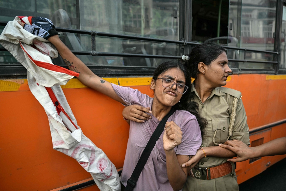 Security personnel detain a demonstrator during a protest demanding the resignation of India's Chief Election Commissioner Gyanesh Kumar over alleged voter roll irregularities linked to the ‘special intensive revision’ (SIR), near Jantar Mantar in New Delhi October 11, 2026. — AFP pic