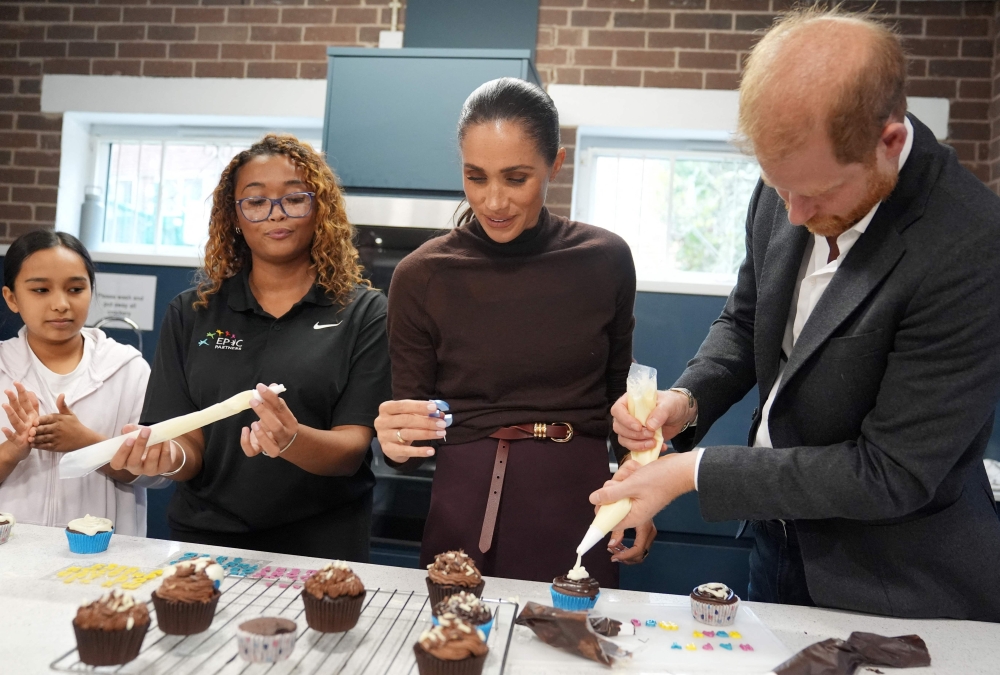 Britain’s Prince Harry, Duke of Sussex and his wife Meghan, Duchess of Sussex, decorate birthday cupcakes during a visit to Epic Partners in Nottingham October 15, 2026.