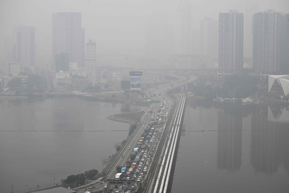 Haze shrouds Johor’s skyline across the Causeway, seen from Singapore on October 16, 2026. — AFP pic