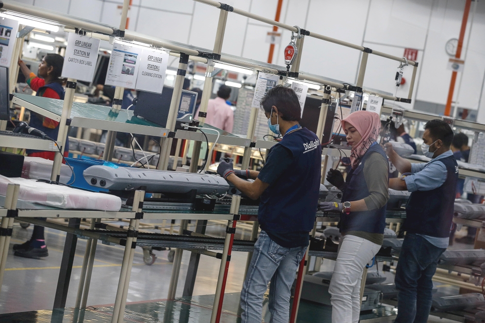 A worker operates machinery on a manufacturing production line in Malaysia, where manufacturers face pressure to improve productivity, manage costs and respond to changing market conditions. — Picture by Sayuti Zainudin