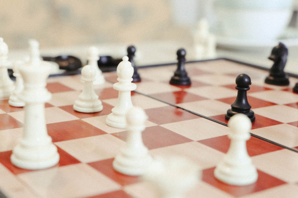 Chess pieces stand on a board, echoing the comparison between learning the rules of a game and understanding the laws that govern everyday life. — Pexels pic