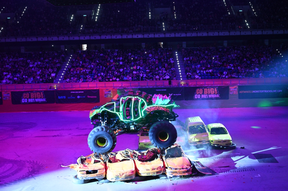 Skelesaurus, driven by Nick Migues, performs a stunt on a pile of Proton cars during the Hot Wheels Monster Trucks Live Glow-N-Fire show yesterday, October 17. — Picture courtesy of MUSE Group Asia 