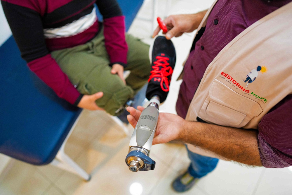 Mahmoud Abou Nusair, a 15-year-old Palestinian boy who lost his right leg during the war in Gaza, has his prosthetic attached at a medical centre in Amman October 13, 2026. — AFP pic