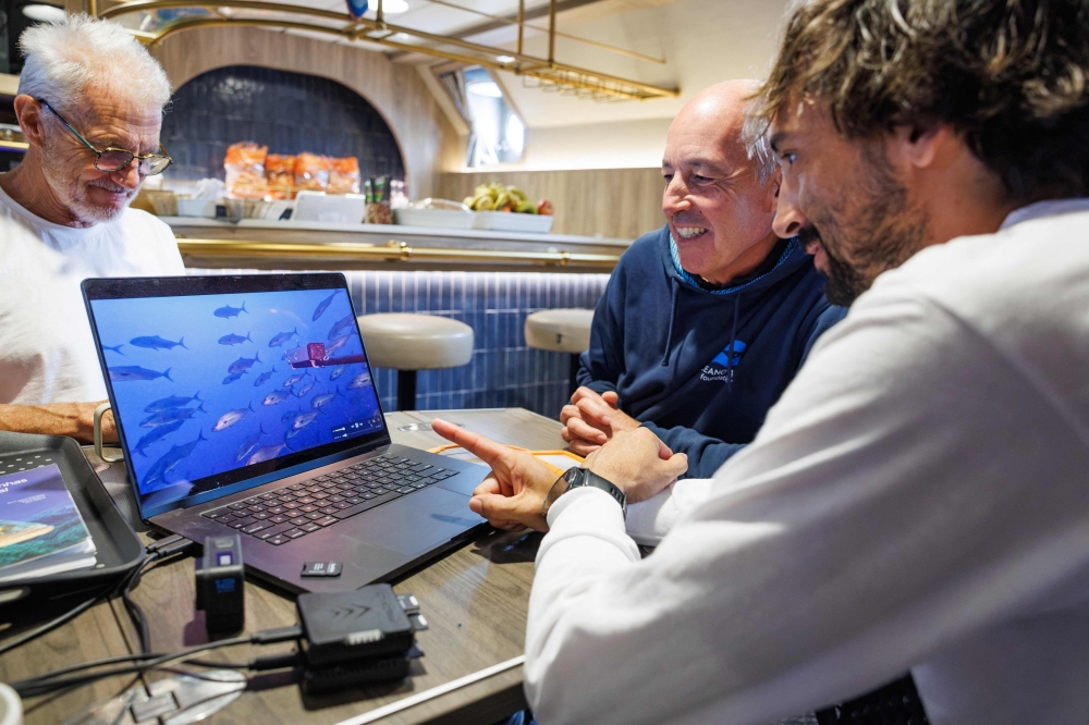 Juan Mayorga, marine scientist with National Geographic Pristine Seas, points to a laptop screen displaying BRUVS underwater footage while reviewing collected data with Emanuel Gonçalves, chief scientist and board member of the Oceano Azul Foundation, inside the ship off the coast of Madeira on October 12, 2026 during the ‘Madeira Ocean’ scientific expedition. — AFP pic 