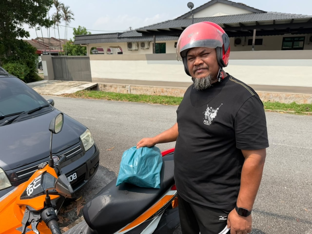 Delivery rider Ghani Jaafar, 50, said he experienced a sore throat and nasal irritation after prolonged exposure to the haze in Johor last week. — Picture by Ben Tan