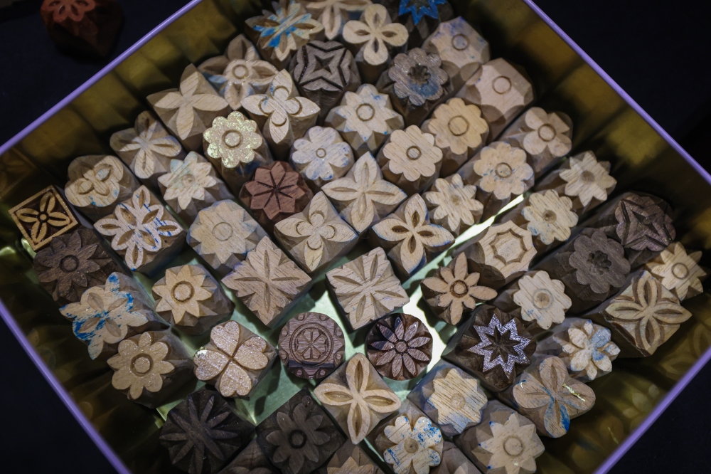 A collection of intricately carved wooden printing blocks featuring floral motifs used in ‘telepuk’, the traditional Malay art of embellishing fabric with gold leaf. — Bernama pic