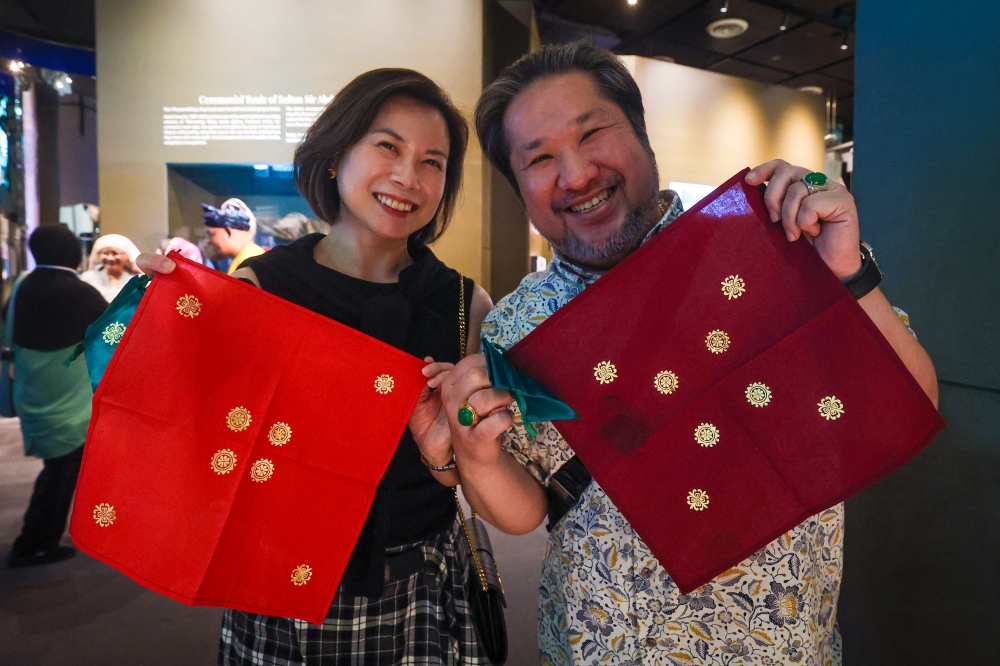 Businessman Winston Tham and his partner proudly display their gold-leaf embellished fabrics after trying their hand at the traditional Malay art of ‘telepuk’ during a heritage workshop at the Royal Selangor Visitor Centre in Kuala Lumpur. — Bernama pic