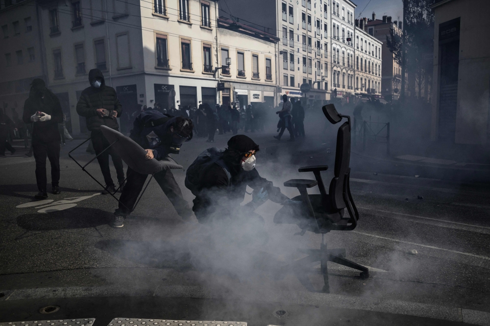 Demonstrators stand amid tear gas with fired by riot police during a high-school students protest as part of a nationwide protest movement over learning conditions in Lyon on October 13, 2026. — AFP pic