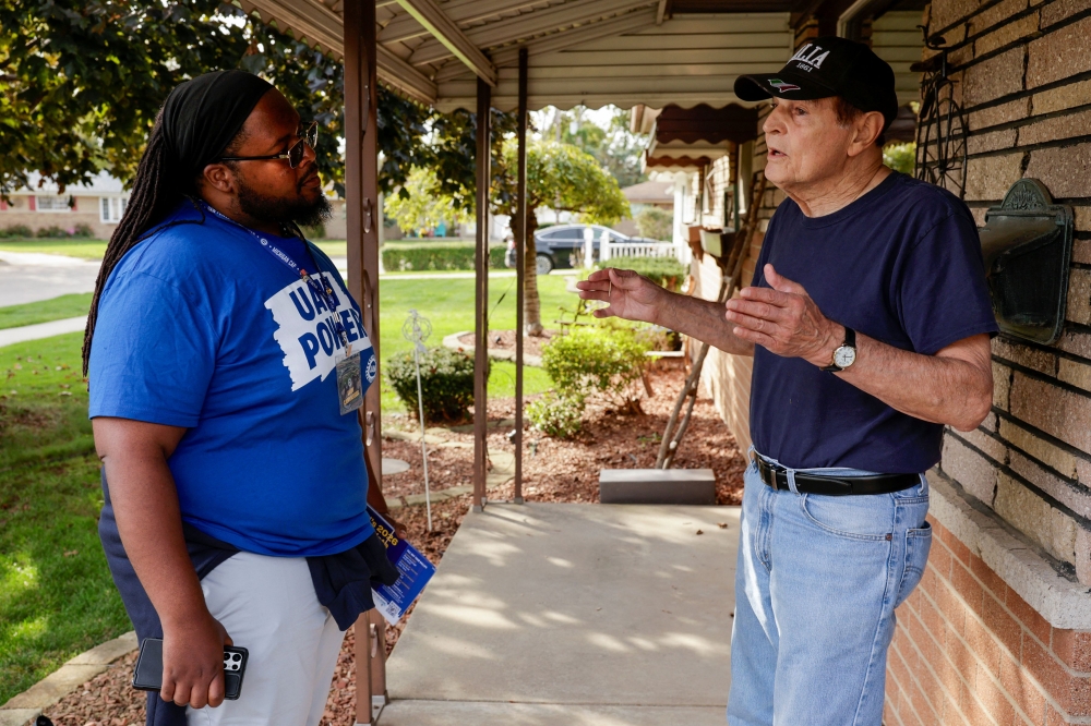 Retired United Auto Workers union member Rich Dimichele (right) speaks with UAW canvasser Maurice Starr about the upcoming midterm elections at his home in Warren, Michigan, on October 10, 2026. — AFP pic 