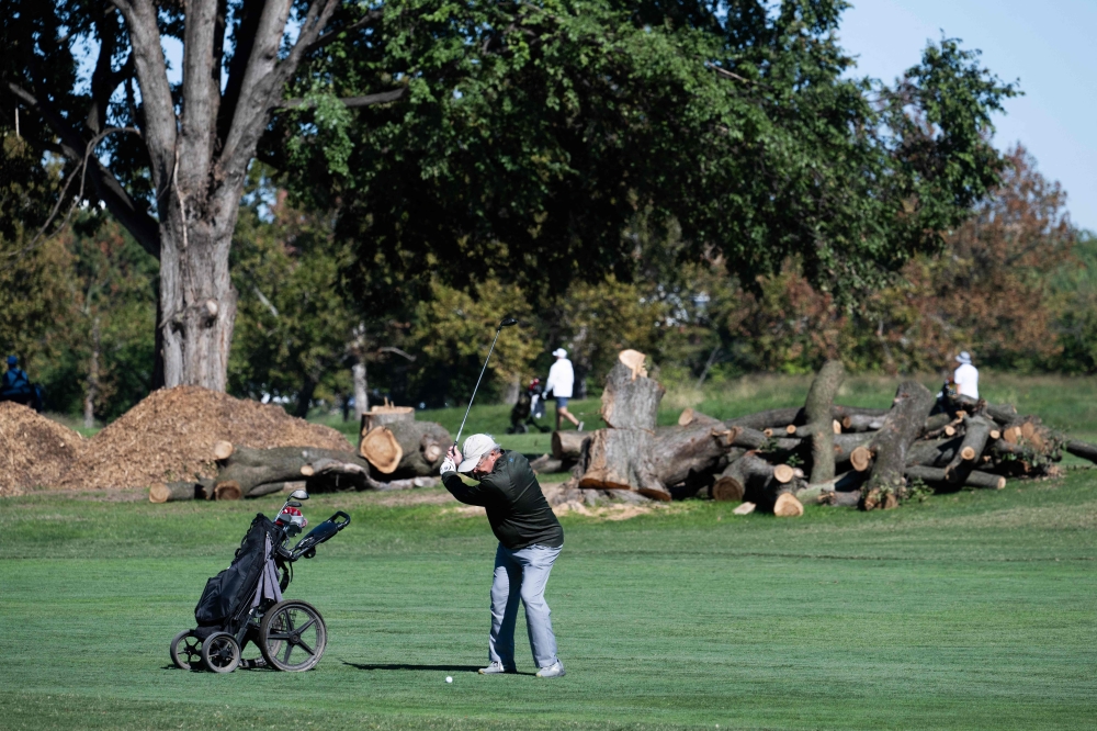 A golfer plays on the course near cut down trees at East Potomac Golf Links near Hains Point in Washington, DC, October 19, 2026. — AFP 