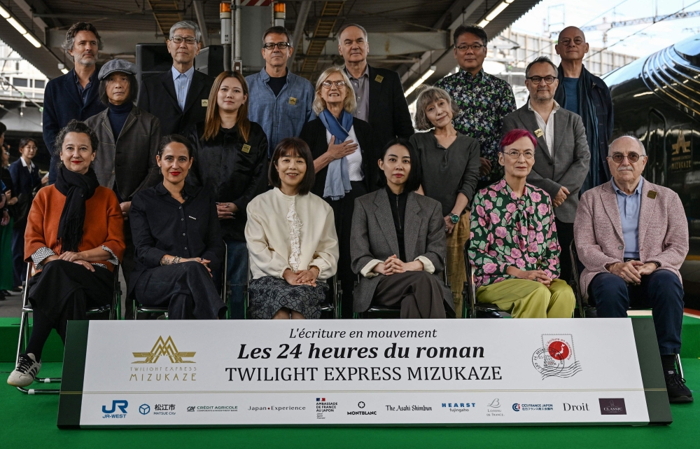 (From left, front) French novelist Muriel Barbery, French writer Claire Berest, Japanese writer Machi Tawara, Japanese writer Mariko Asabuki, Japanese author Anna Ogino and French writer Paul Fournel; (from left, middle) Japanese writer Hitonari Tsuji, Japanese novelist Hitomi Kanehara, “L’Ecriture en mouvement” association founder Anne Forrest-Wilson, Japanese author Kaori Ekuni and French poet Frederic Forte; and (from left, rear) French writer Christophe Ono-dit-Biot, Japanese poet Hisaki Matsuura, Argentine writer Eduardo Berti, French writer Herve Le Tellier, Japanese author Toh EnJoe and French author Richard Collasse pose for a group photo at Shin-Osaka station in Osaka prefecture on October 22, 2026. — AFP pic