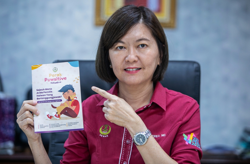 Perak Housing and Local Government Committee chairman Sandrea Ng Shy Ching shows a Perak Pawsitive Initiative leaflet at the Perak Darul Ridzuan Building in Ipoh recently. — Bernama pic
