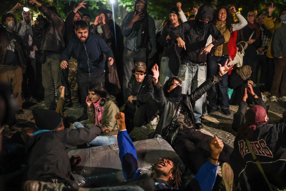 Protesters lie on the ground and shout slogans during a protest against housing shortage, soaring rents and low wages at Rossio square in Lisbon October 22, 2026. — AFP pic