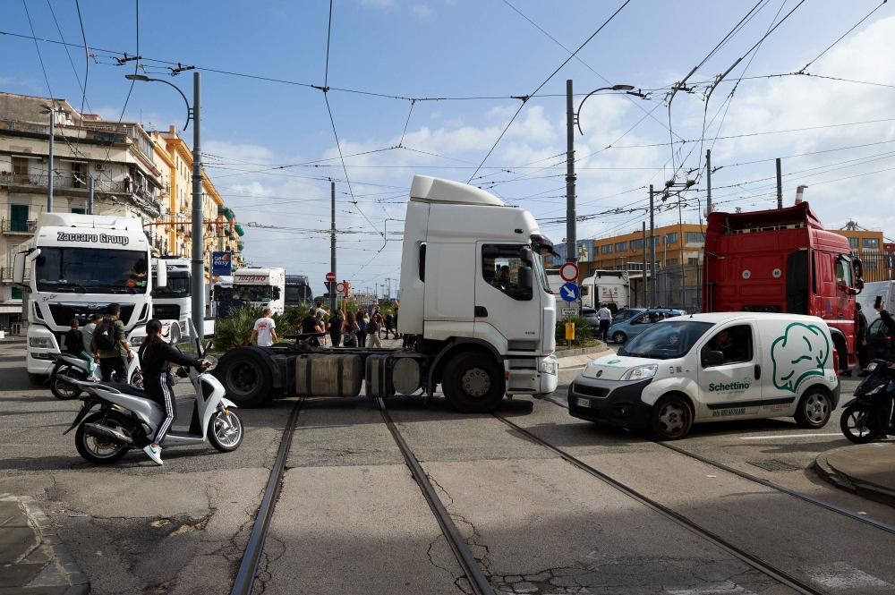 Truck drivers block streets and tram tracks near the port of Naples, Italy on October 22, 2026, during a protest against rising fuel costs. A second round is expected this weekend. — AFP pic