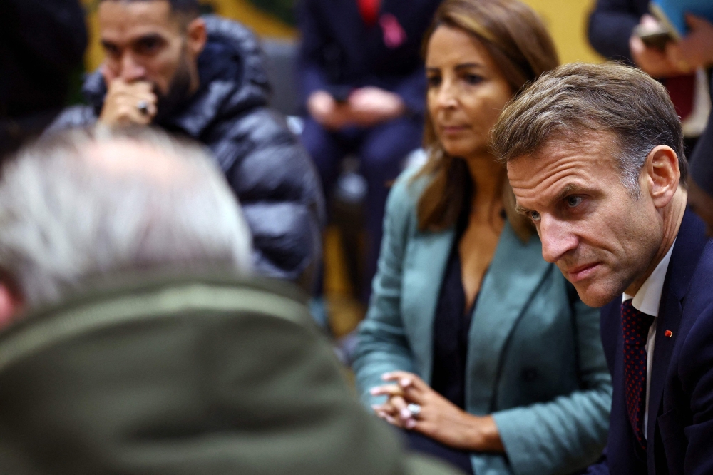 French President Emmanuel Macron speaks with community members at the town hall in Trappes, near Paris, on October 23, 2026.  — AFP pic