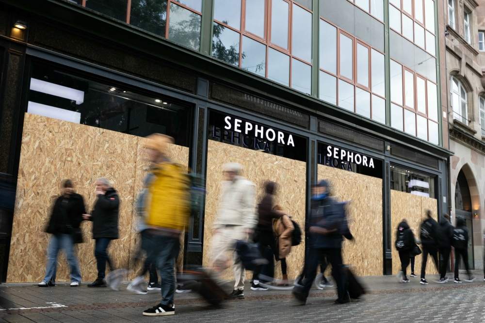 Pedestrians walk past a Sephora shop boarded-up with plywood in Strasbourg October 24, 2026. — AFP pic