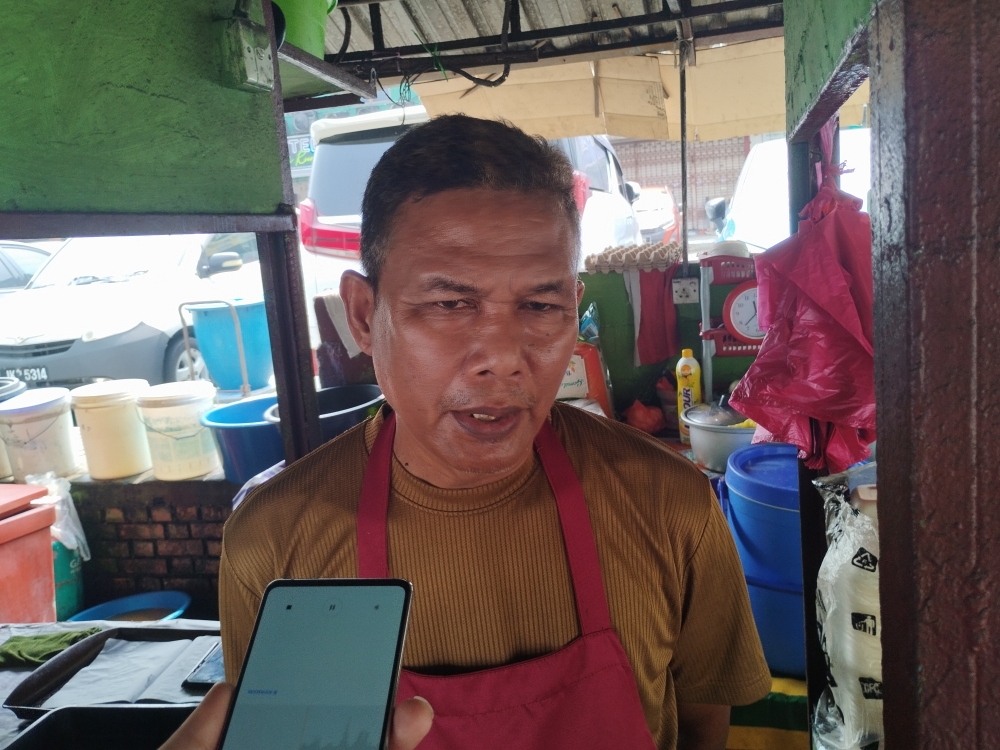 Che Daud Che Isa, 59, said the ongoing haze has affected business at his food stall in Taman Sri Rampai, Kuala Lumpur, with customer numbers down by about half. — Picture by Muhammad Yusry