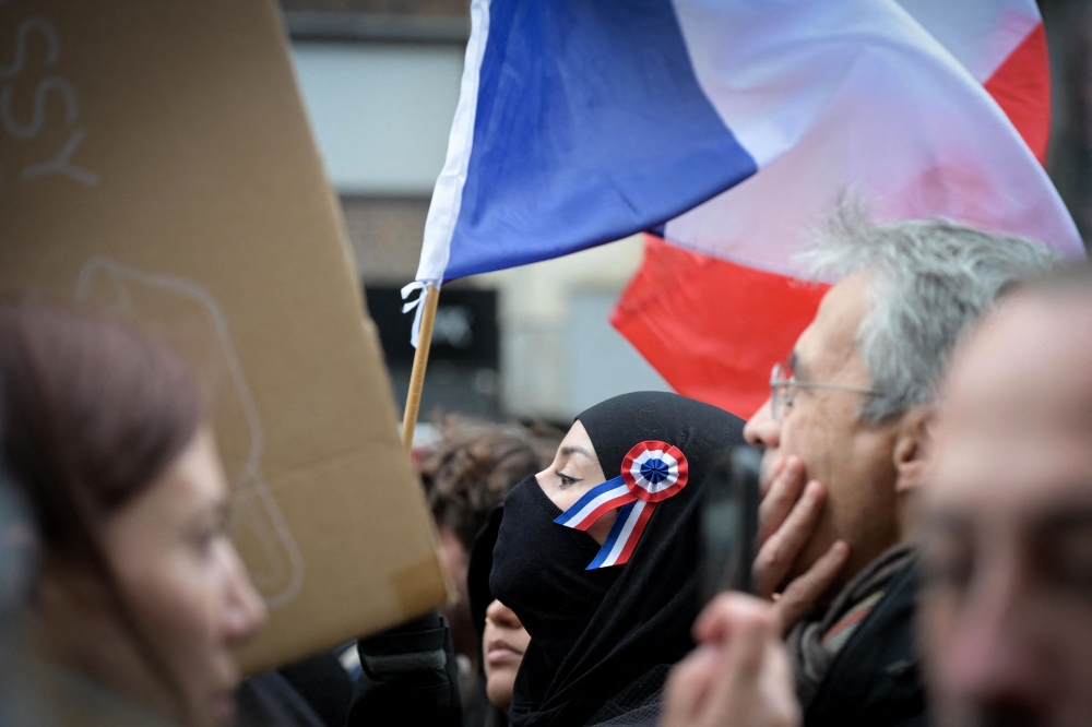 A protester carries a French tricolour flag during a demonstration calling for increased purchasing power, the protection of public services, and fiscal and social justice in Paris on October 24, 2026. — AFP pic