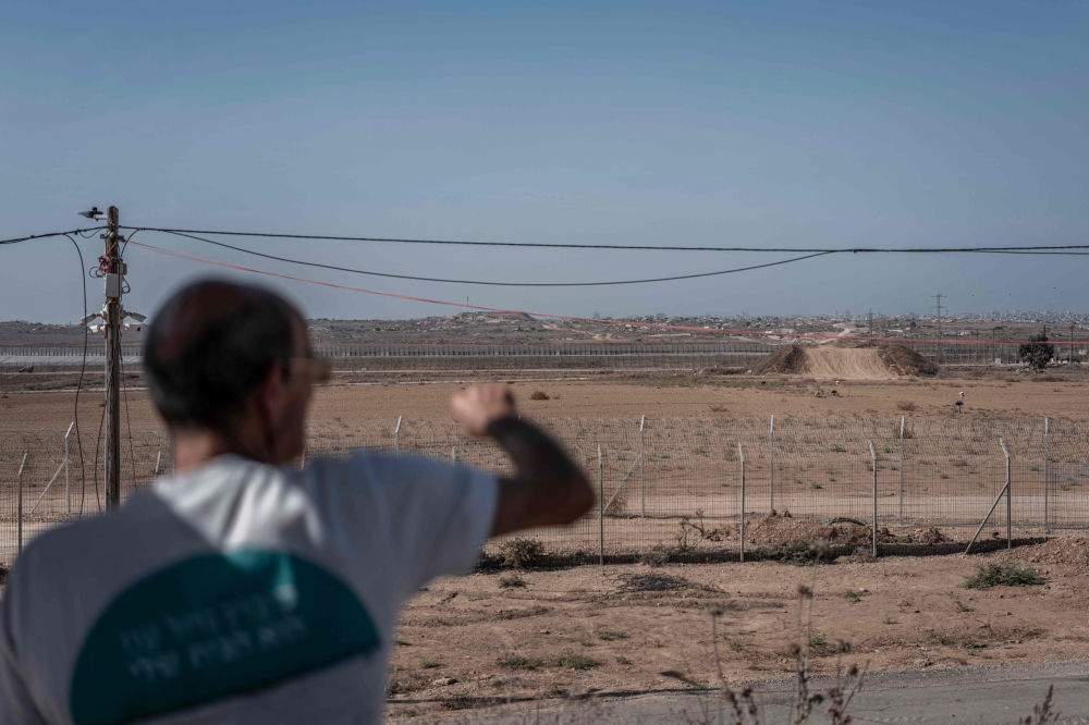 Danny, a resident Kibbutz of Nahal Oz, points at the adjacent Gaza border, at the Israeli Kibbutz of Nahal Oz in southern Israel on October 22, 2026. — AFP pic
