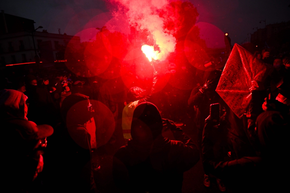A protester lights a flare near Porte de Vincennes during a nationwide demonstration over rising living costs and public services in Paris on October 24, 2026. — AFP pic
