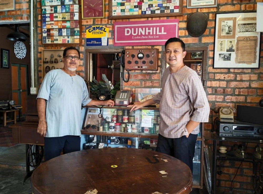 Hamdzan Ali with his son-in-law, Safuan Mohd Pikri. Hamdzan established the eatery as a space to share his passion for antiques with the public. — Bernama pic