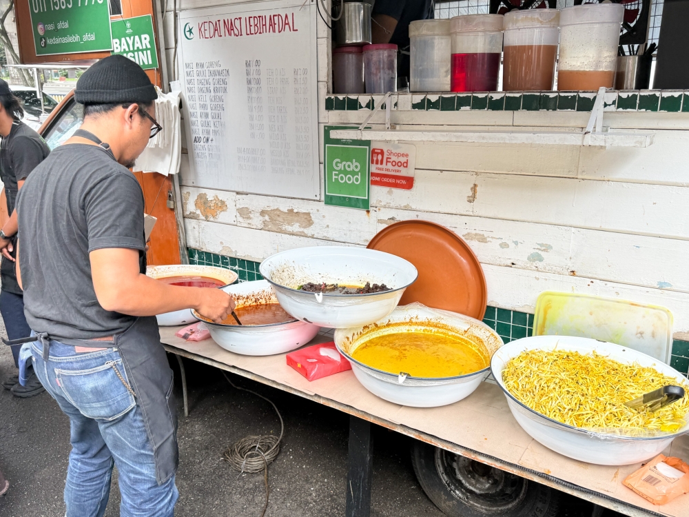 The rice is drenched with a mix of different ‘gulai’ from the huge enamel tubs like ‘gulai ikan masin’, ‘gulai daging kerutuk’ and ‘gulai kopeh’ — Picture by Lee Khang Yi