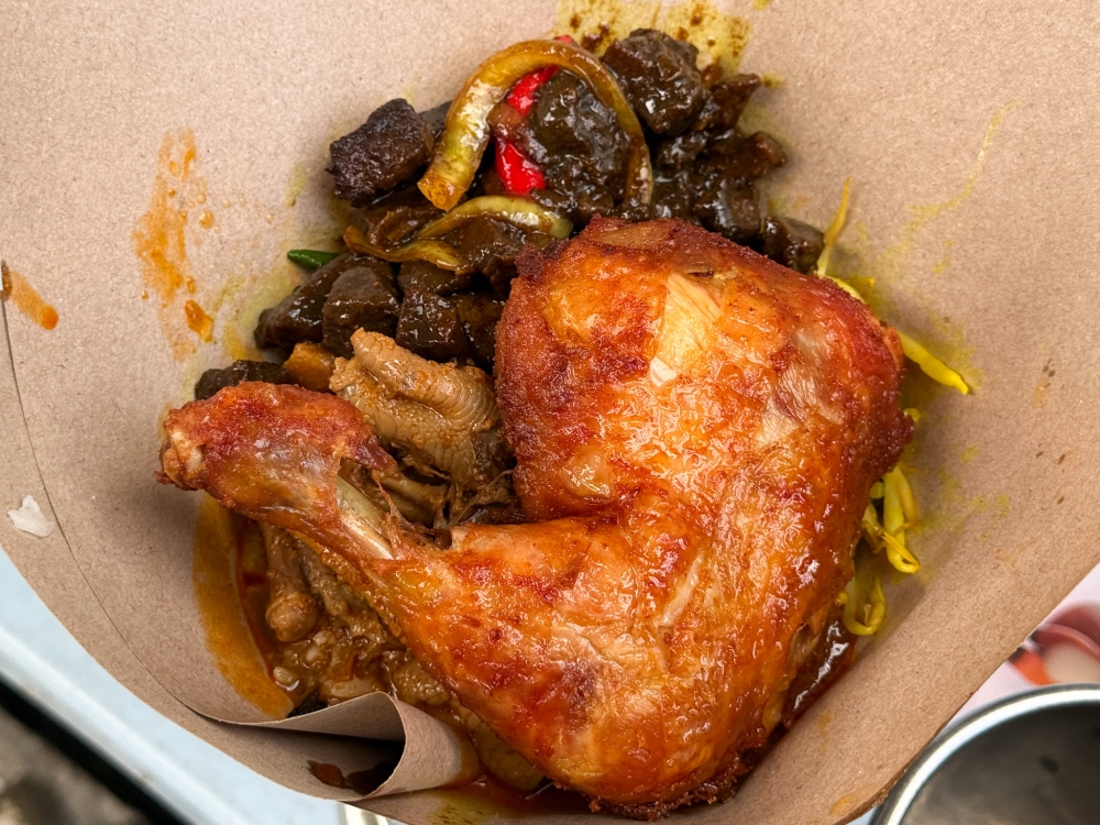 Each packet is shaped into a cone as you pick what you want, including a fried chicken leg, ‘daging goreng’ and even their ‘gulai kopeh’ with chicken feet — Picture by Lee Khang Yi