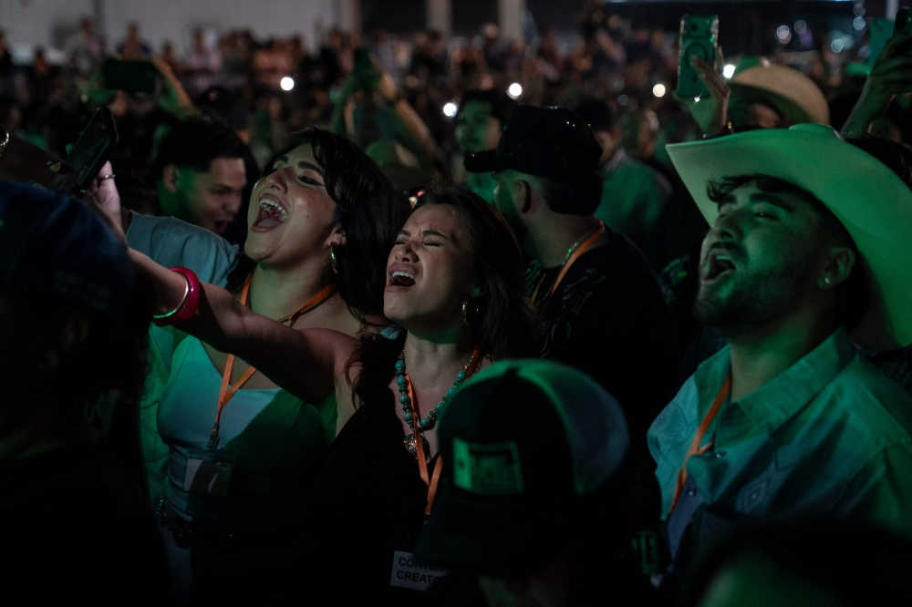 People sing along Los Tigres del Norte and Bobby Pulido during a joint campaign event in Weslaco, Texas October 25, 2026. 