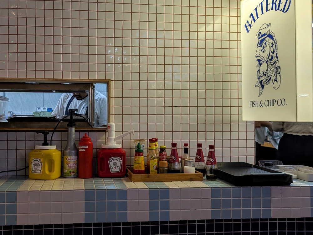 The condiment station is well stocked with all sorts, but the essentials are malt vinegar and chip spice. — Picture by Ethan Lau