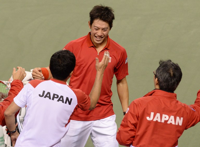 Japan's Kei Nishikori (centre) is congratulated by his teammates after his victory during their men's doubles tennis match of the Davis Cup World Group First Round in Tokyo on February 1, 2014. u00e2u20acu201d AFP pic