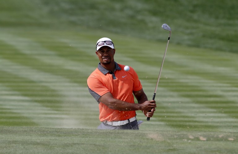 US Tiger Woods eyes the ball after playing a shot during the third round of the 2014 Omega Dubai Desert Classic on February 1, 2014 in Dubai, United Arab Emirates. u00e2u20acu201d AFP  pic