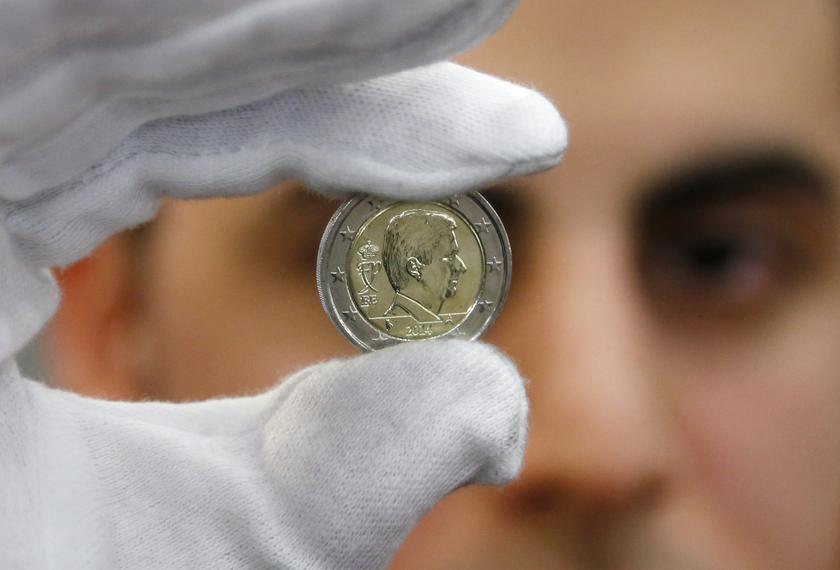 A worker displays a newly minted two-euro coin with the portrait of Belgian King Philippe at Belgium's Royal Mint in Brussels February 4, 2014. u00e2u20acu201d Reuters pic