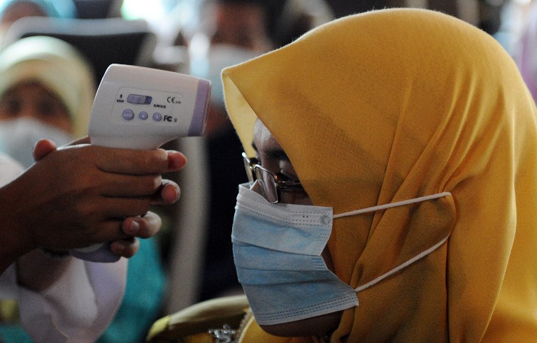 A Malaysian health worker checks the temperature of a passenger in an effort to detect the presence of the H1N1 virus inside a bus in Kuala Lumpur on September 14, 2009. Health officials confirmed that 8 people in Sabah have contracted the virus. u00e2u20acu201d AFP 