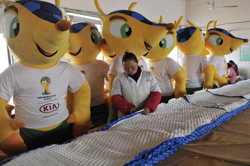 An employee works in front of newly made giant dolls of Fuleco the Armadillo, the official mascot of the FIFA 2014 World Cup, at a factory in Tianchang, Anhui province January 6, 2014. u00e2u20acu201d Reuters pic