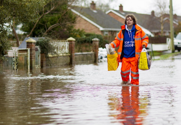 A man walks through flooded streets in the village of Moorland in Somerset, south-west England, on February 6, 2014. u00e2u20acu201d AFP pic