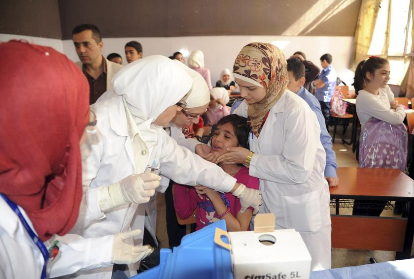 Syrian health workers administer polio vaccination to a girl at a school in Damascus, in this file photo taken by Syria's national news agency SANA on October 20, 2013. u00e2u20acu201d Reuters pic 
