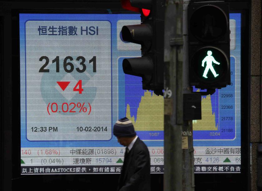 A man walks past a panel displaying half-day trading Hang Seng Index outside a bank in Hong Kong February 10, 2014. u00e2u20acu201d Reuters pic