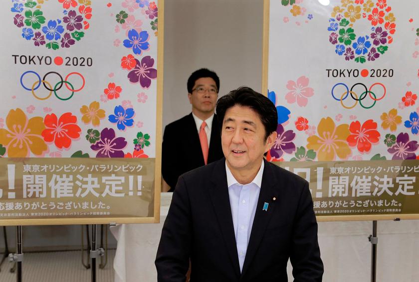 Japan's Prime Minister Shinzo Abe smiles as he reports to his cabinet members Tokyo's successful bid to host the 2020 Summer Olympics and Paralympics at the IOC meeting after returning from Buenos Aires, Argentina, during a cabinet meeting at the prime mi