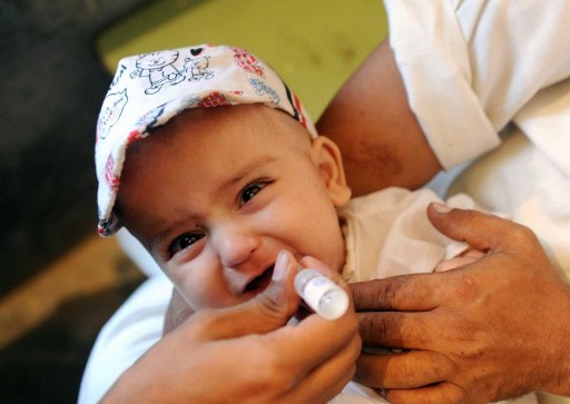 A Pakistan health worker gives polio vaccine drops to a child in Peshawar, September 11, 2012.u00e2u20acu201d AFP pic