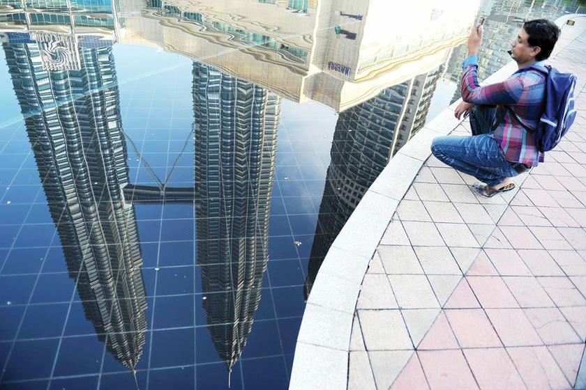 Time to reflect: A visitor takes pictures of Malaysiau00e2u20acu2122s landmark Petronas Towers in Kuala Lumpur. u00e2u20acu201d AFP pic