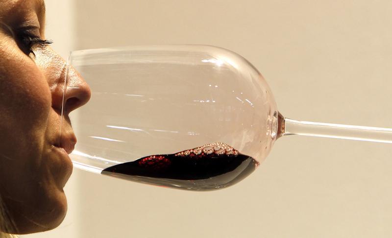 A woman tests a glass of red wine during the Vinitaly wine expo in Verona, April 8, 2011. u00e2u20acu201d Reuters pic