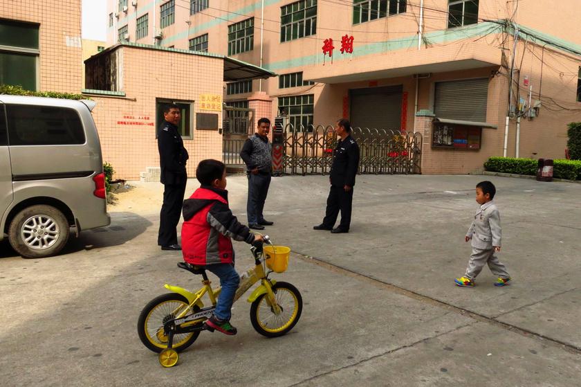 Security guards and children stand on a quiet street outside the shuttered Shenzhen Kexiang Mould Tool Co Ltd factory in the town of Fuyong, on the outskirts of Shenzhen in this February 6, 2014 file photo. u00e2u20acu201d Reuters pic