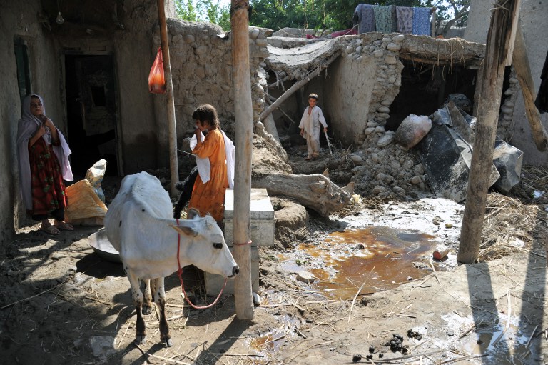 Afghan residents stand in the compound of their flood-damaged home after the waters receded in Surobi district of Kabul province on August 7, 2013. u00e2u20acu201d AFP pic