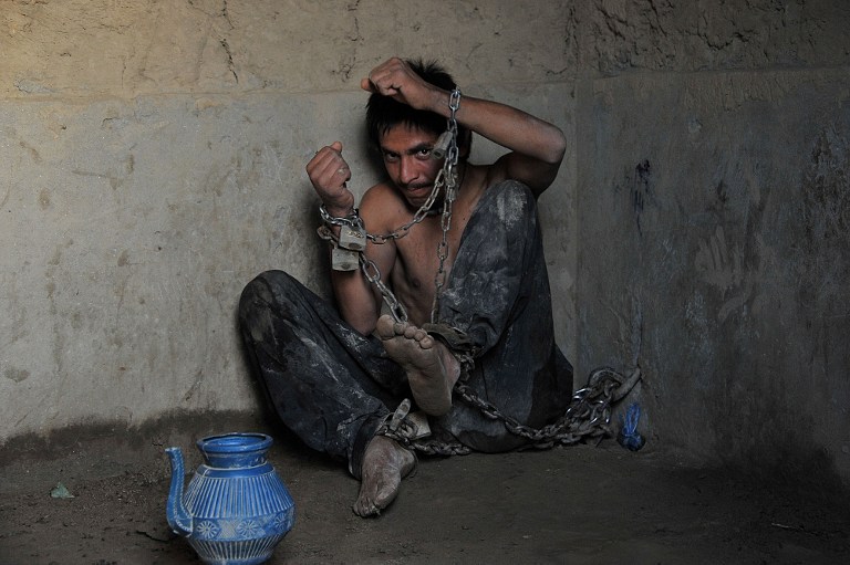 A mentally ill Afghan patient sits chained to a wall at the Mia Ali Baba holy shrine in the village of Samar Khel on the outskirts of Jalalabad on May 16, 2013. u00e2u20acu201dAFP pic