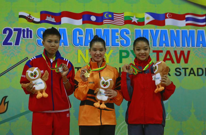Gold medalist Tai Cheau Xuen from Malaysia (centre), silver medalist Aint Mi Mi from Myanmar and bronze medalist Juwita Niza Wasni Wasni (right) from Indonesia pose with their medals after the women's u00e2u20acu02dcNandaou00e2u20acu2122 wushu competition during the 27th SEA Gam