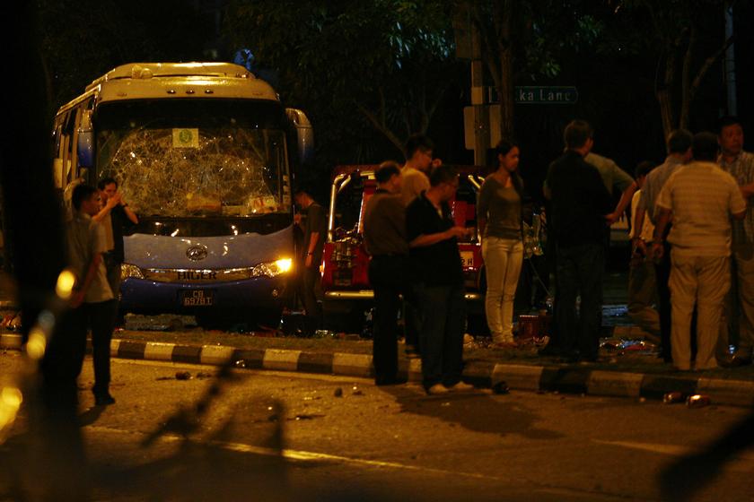Officials stand around a bus with a smashed windshield following a riot in Singapore's Little India district. December 9, 2013. u00e2u20acu2022 Reuters pic 