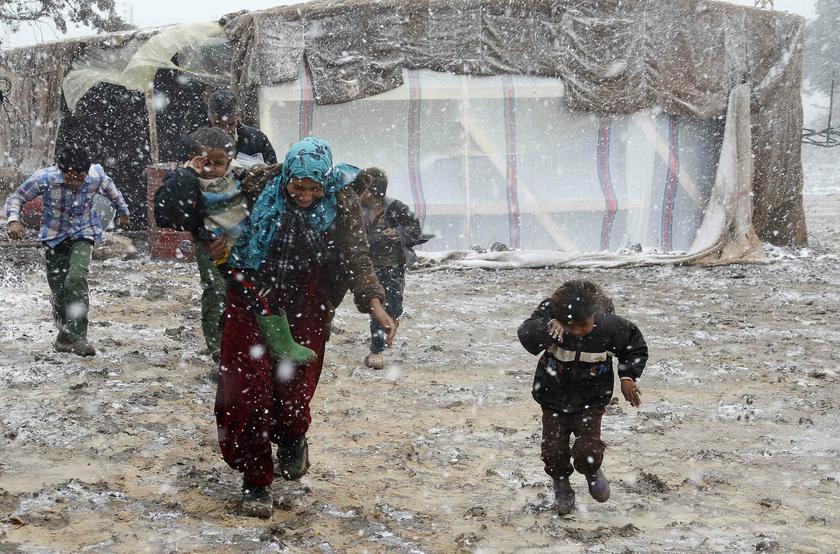 Syrian refugees run for cover from snow during a winter storm in Zahle town, in the Bekaa Valley, December 12, 2013. u00e2u20acu2022 Reuters pic