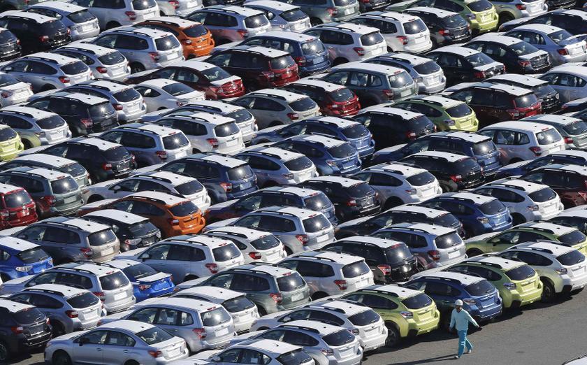 A worker walks beside newly produced cars at Keihin industrial zone in Kawasaki, south of Tokyo December 16, 2013. u00e2u20acu201d Reuters pic