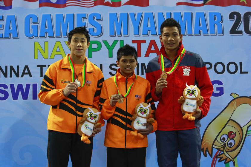 Gold medallist Muhammad Nazreen Abdullah (centre) of Malaysia, silver medallist and compatriot Ooi Tze Liang (left) and bronze medallist Adityo Restu Putra ofIndonesia pose with their medals after the men's 10m platform final during the 27th SEA Games in 