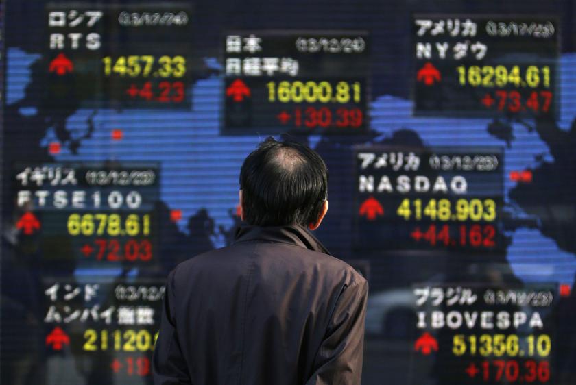 A pedestrian looks at an electronic board displaying various countries' stock market indices outside a brokerage in Tokyo. u00e2u20acu201d Reuters pic